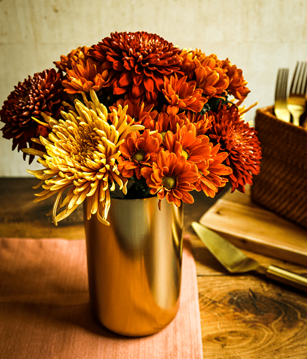 A Floral Arrangement in a Gold Vase Featuring Heinen's 3 for $18 Floral