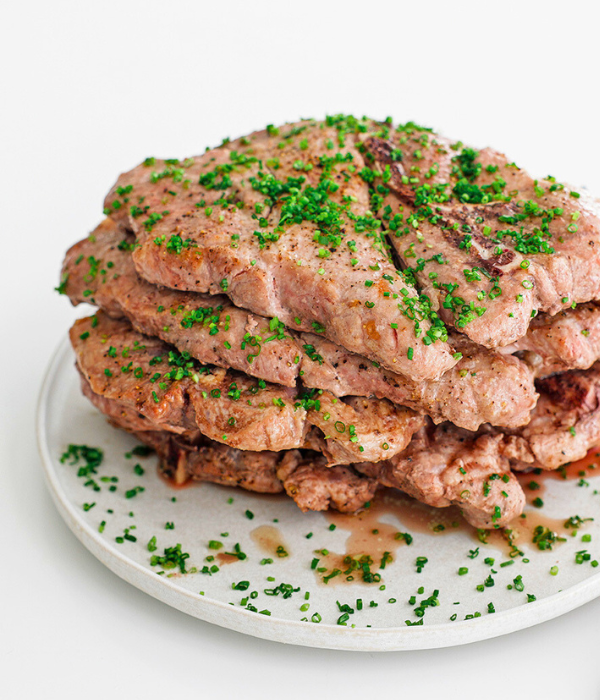 4 Cooked Pork Steaks on a white plate