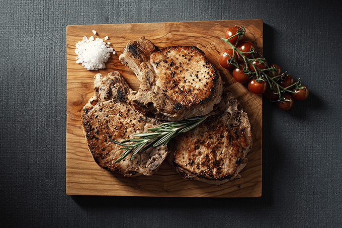 Bone-in pork chop on a wooden board