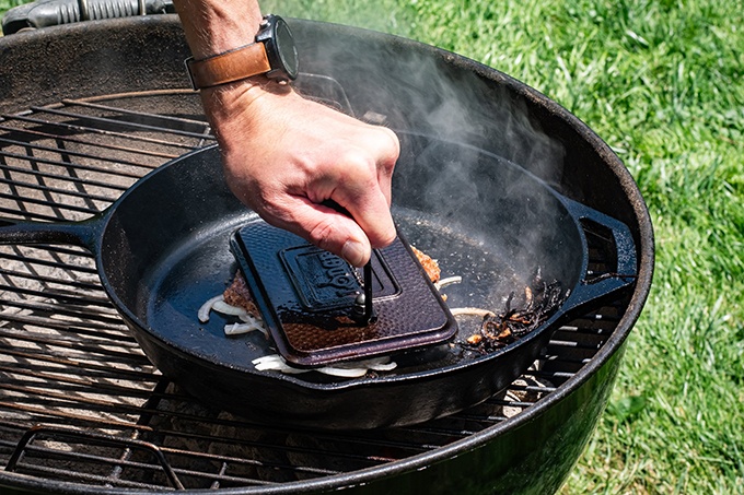 Grill Press being used to make a Smash Burger on a skillet on the grill