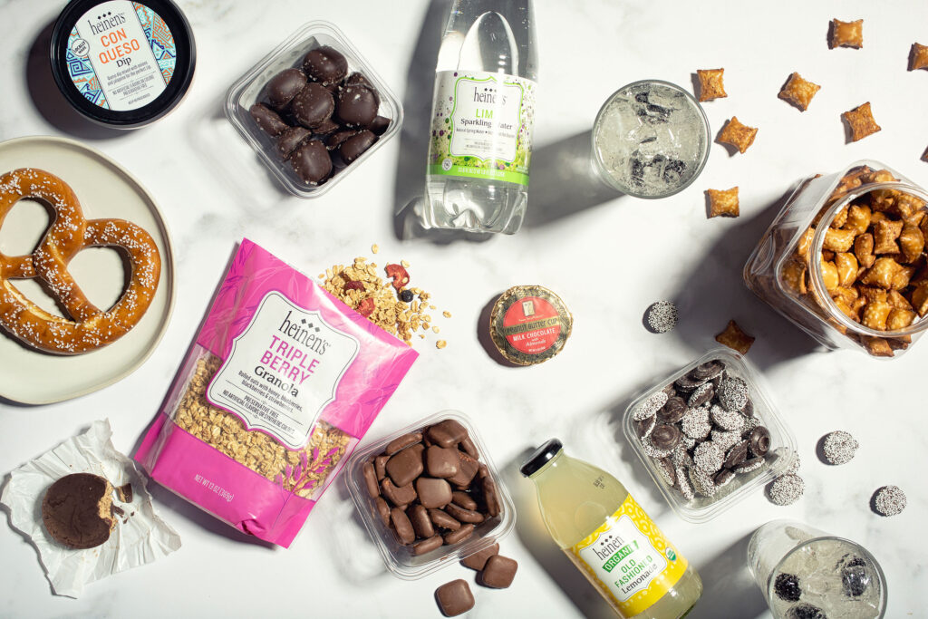 A variety of Heinen's brand label products including sparkling water, granola, chocolates, lemonade, dips, and pretzels.