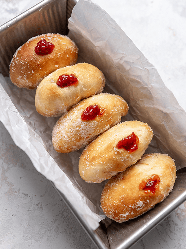 A Close Up Image of Five Air Fryer Jelly Donuts in a Bread Baking Pan