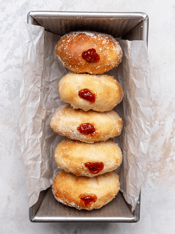 A Vertical Image of Five Air Fryer Jelly Donuts in a Bread Baking Pan