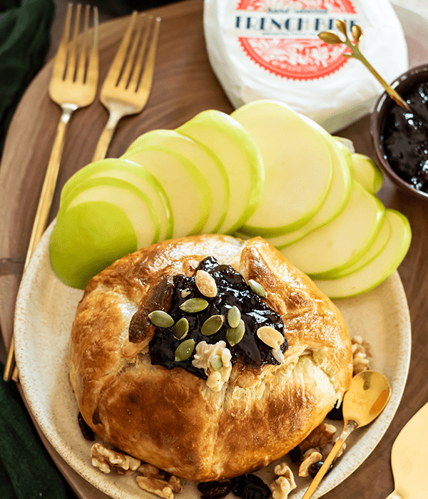 Baked Brie en Croute Topped with a Fruit Spread and Nuts and Served with Fresh Sliced Apples