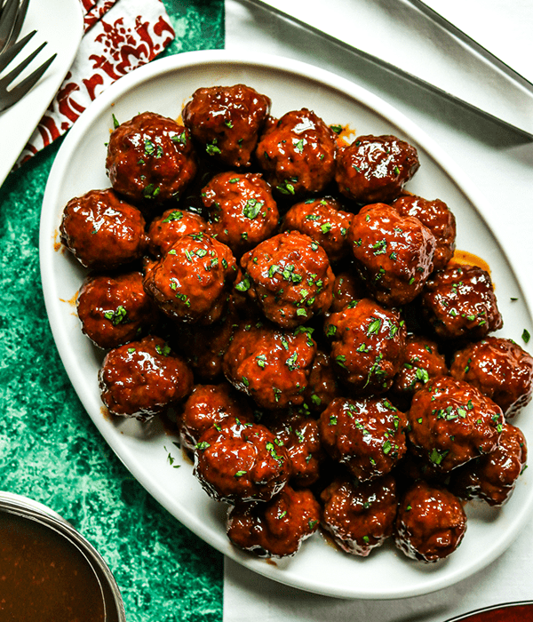 A Top Down Close Up Image of a Serving Tray Full of Grape Jelly Meatballs