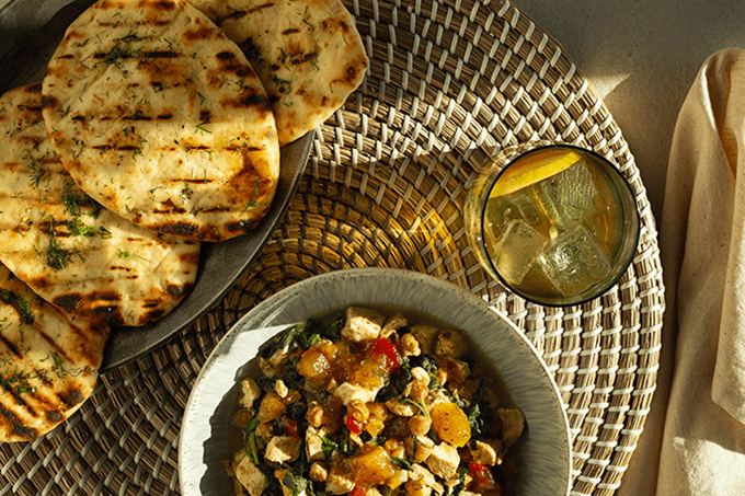 Bowl of Coconut Curry Chicken with a side of garlic naan. 