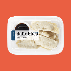 Container of Daily Bites Dumplings with soy sauce. 