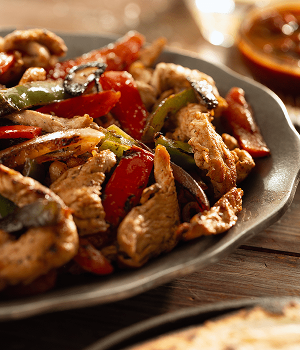 Chicken Fajitas with Charred Peppers and Onions on a Dinner Plate