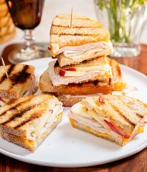 Stacked slices of an apple cheddar turkey panini